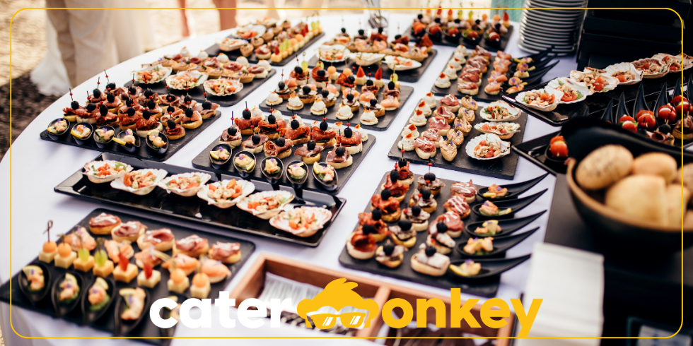 Catering-Buffet mit verschiedenen Häppchen und Canapés auf einem weißen Tisch