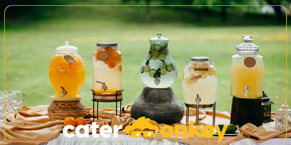 Distributori di bevande in vetro con frutta a un evento catering all'aperto