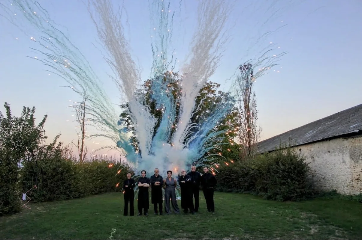 L'équipe d'Epicura Réceptions devant un feu d'artifice, dans un jardin